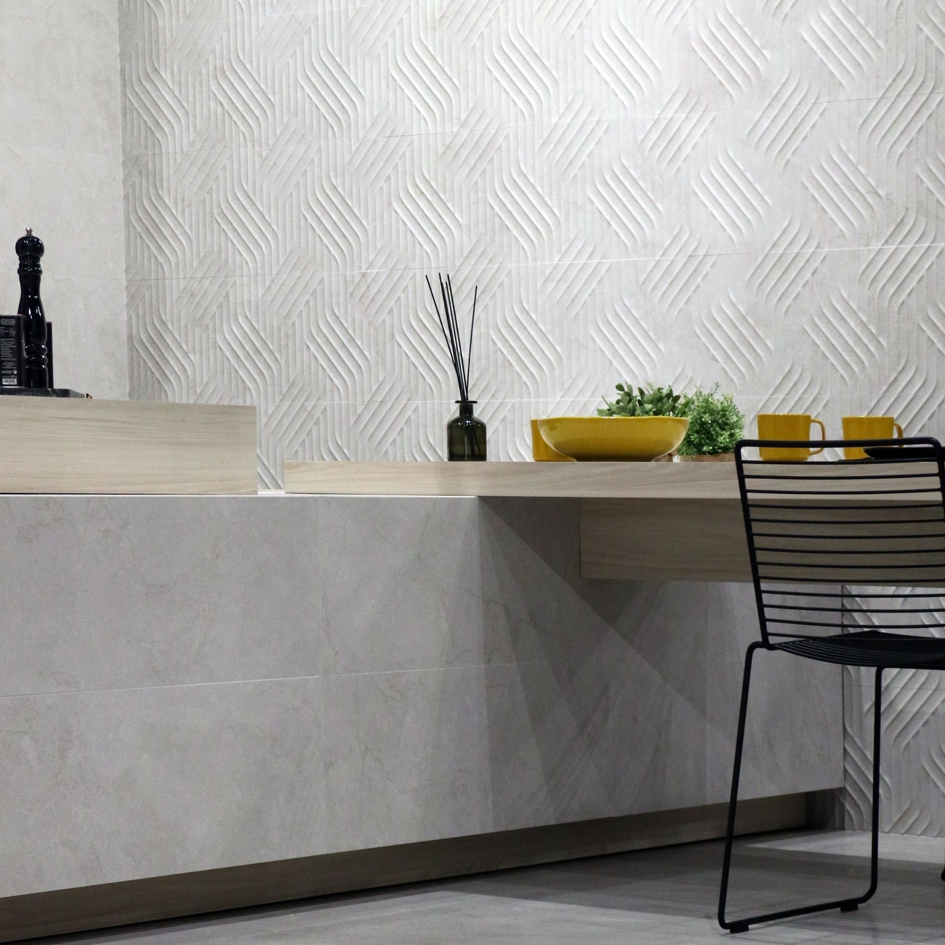 Modern kitchen with Pensford white stone-effect countertop tiles and a black chair.