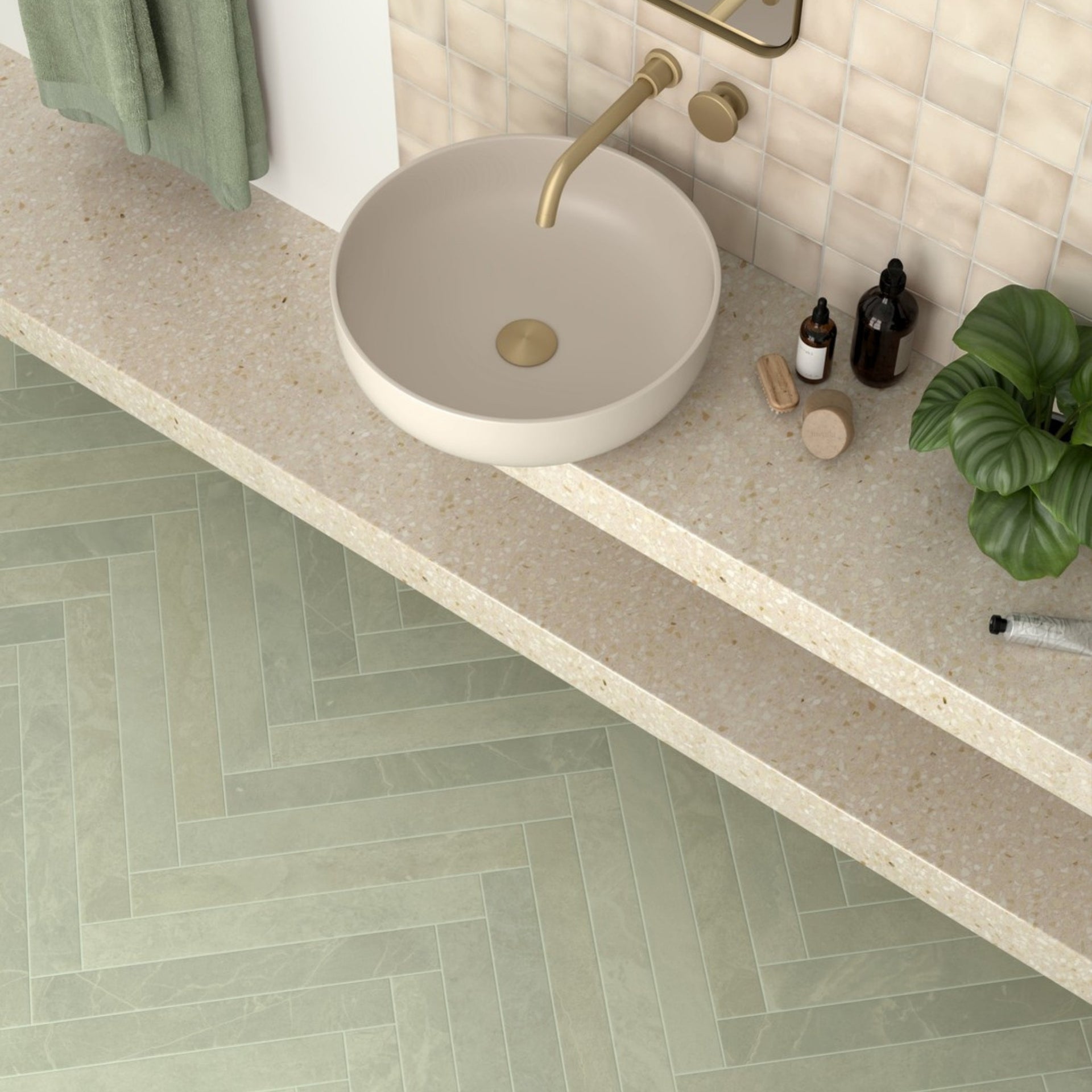 Bathroom with a round concrete sink, gold faucet, and tiled floor with green tones.