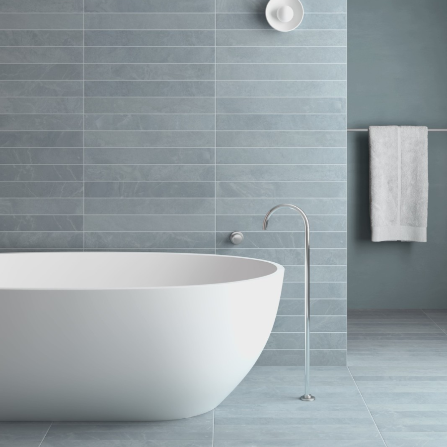 Modern bathroom with a freestanding bathtub against a tiled wall.