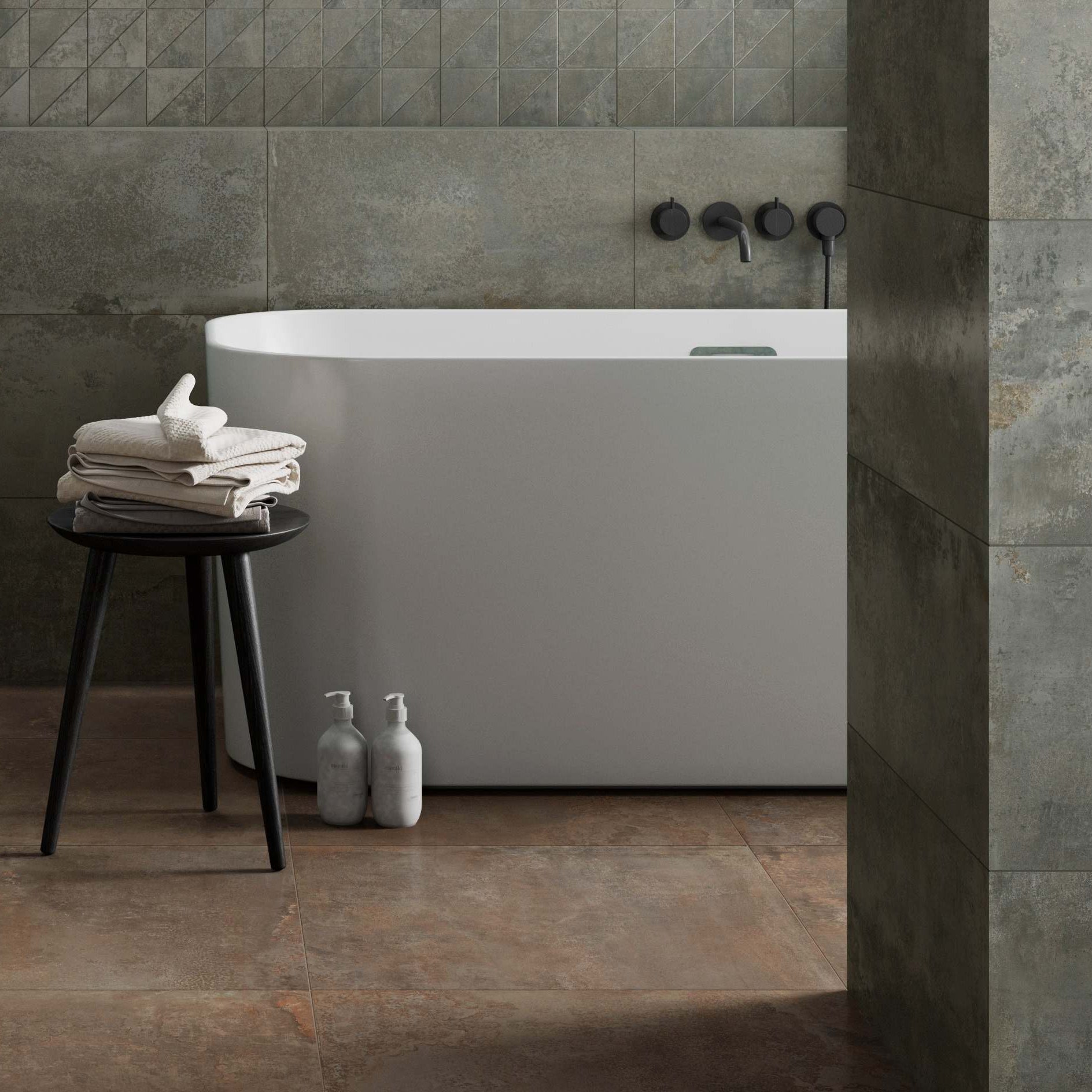 Modern bathroom with a freestanding bathtub against tiled walls.