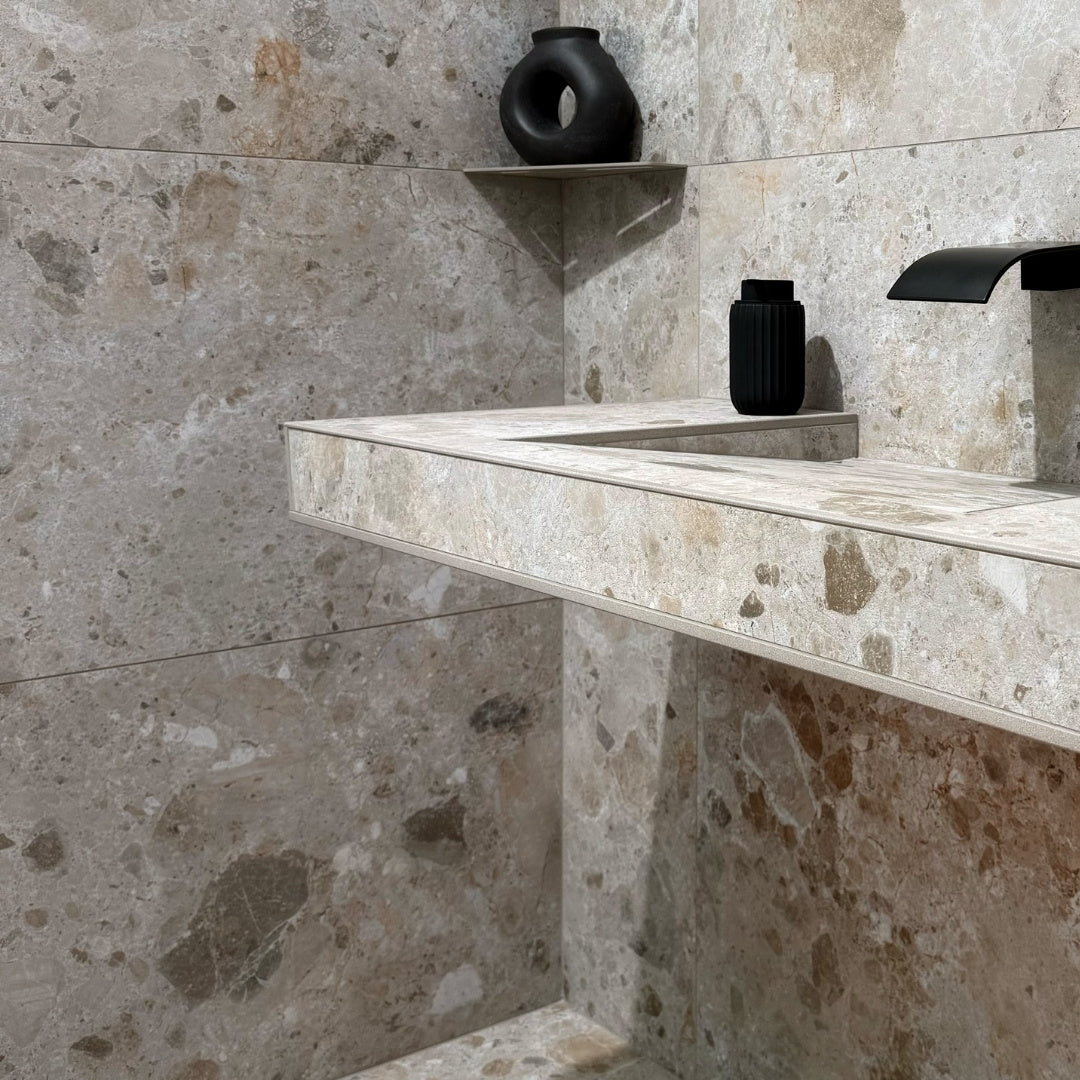 Bathroom vanity with Cordoba Taupe stone-like tiles and black hardware and decor.