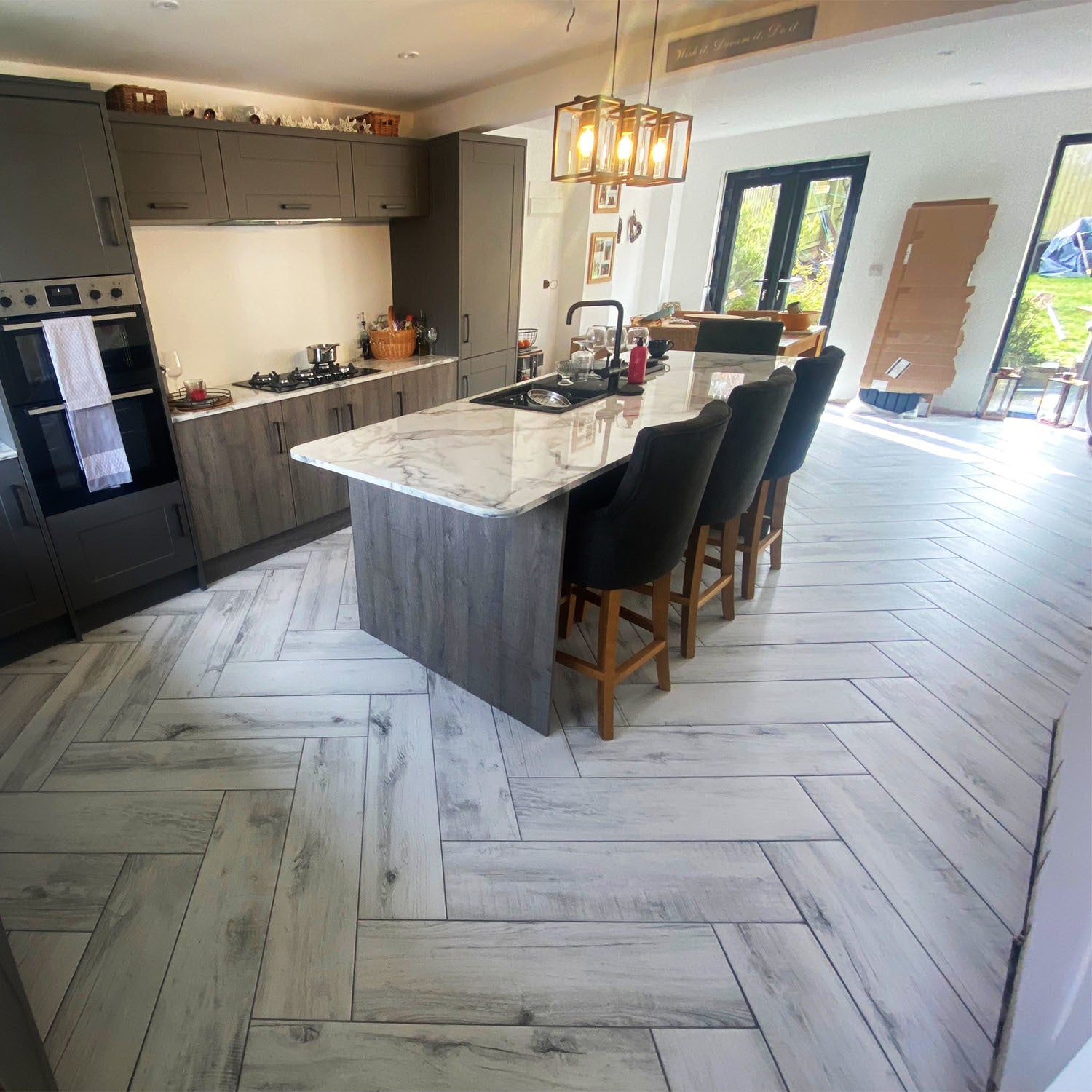 Modern kitchen with black cupboards and grey counter table, featuring white wood effect floor tiles.

layout-kitchen