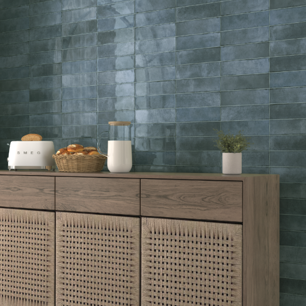 Wooden sideboard with kitchen items against a blue tiled wall