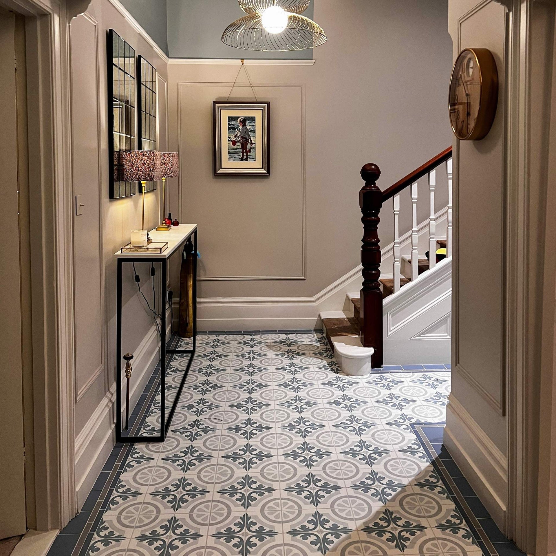 Foyer with patterned floor tiles, staircase, and wall decor.

layout-hallway