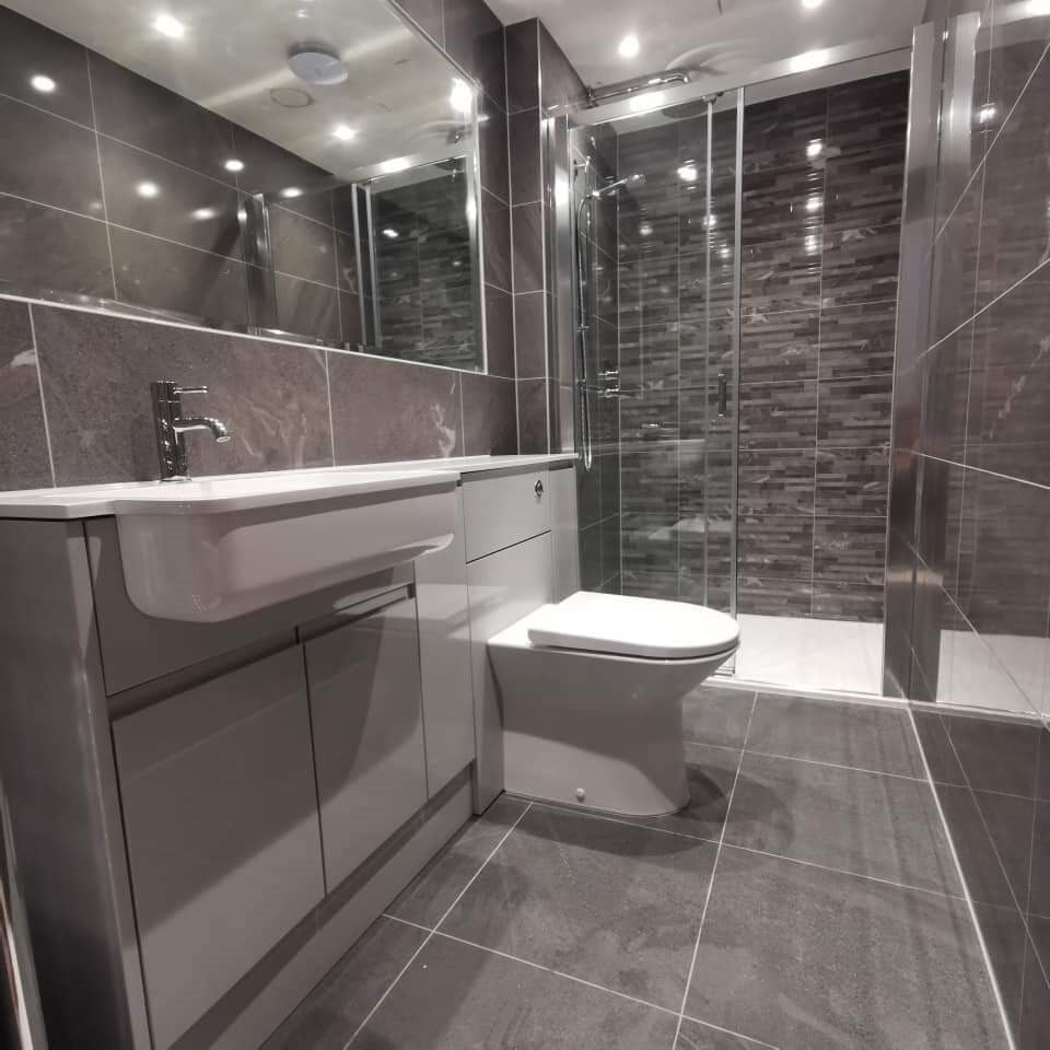 Modern bathroom with dark grey tiles, a sink, and a toilet.

layout-bathroom