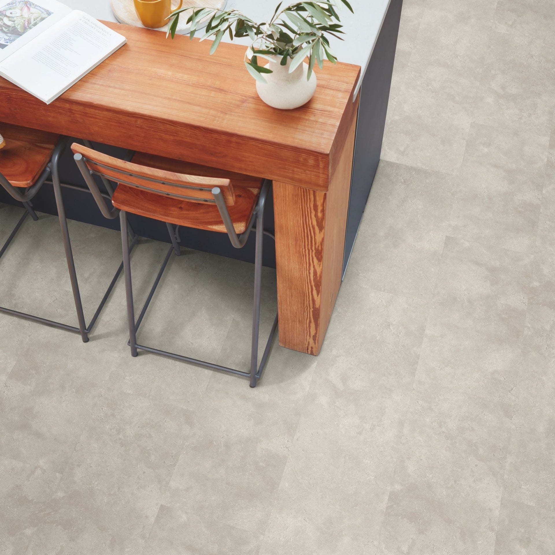 Wooden dining table with chairs on a grey stone effect luxury vinyl tiled floor