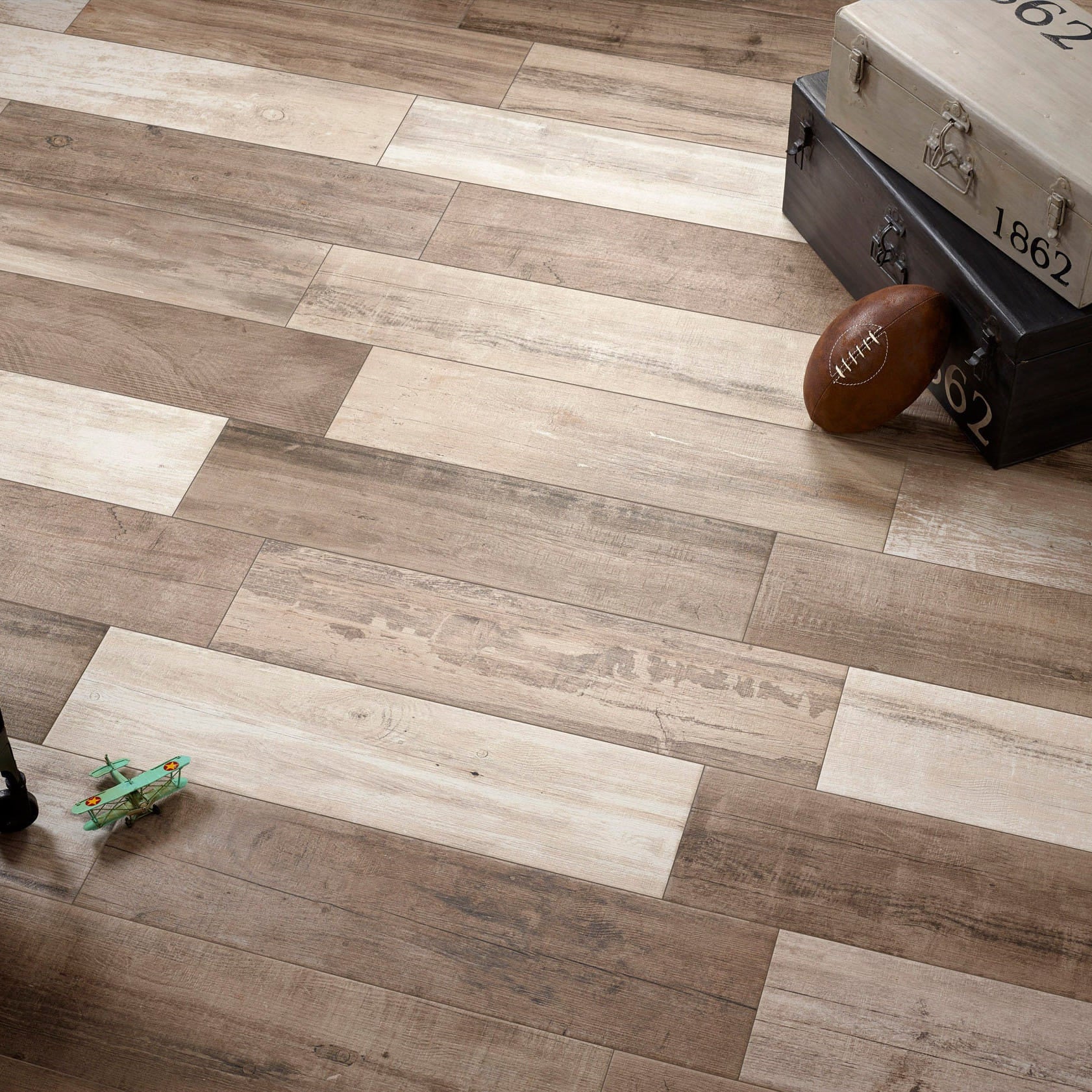 Vancouver wooden floor tiles with a suitcase, football, and toy on it.