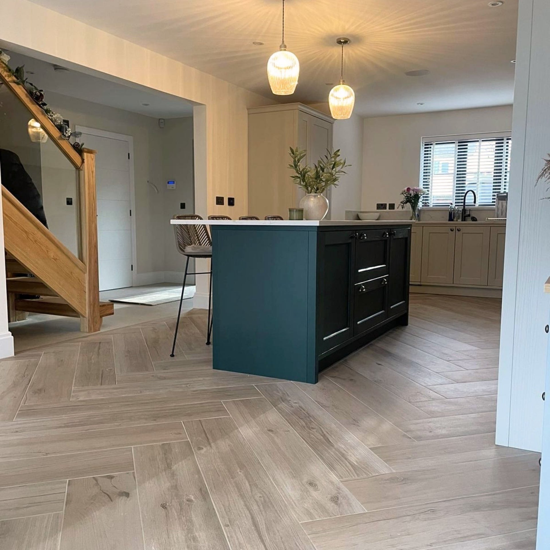 Modern kitchen with teal island and maple wood effect floor tiles