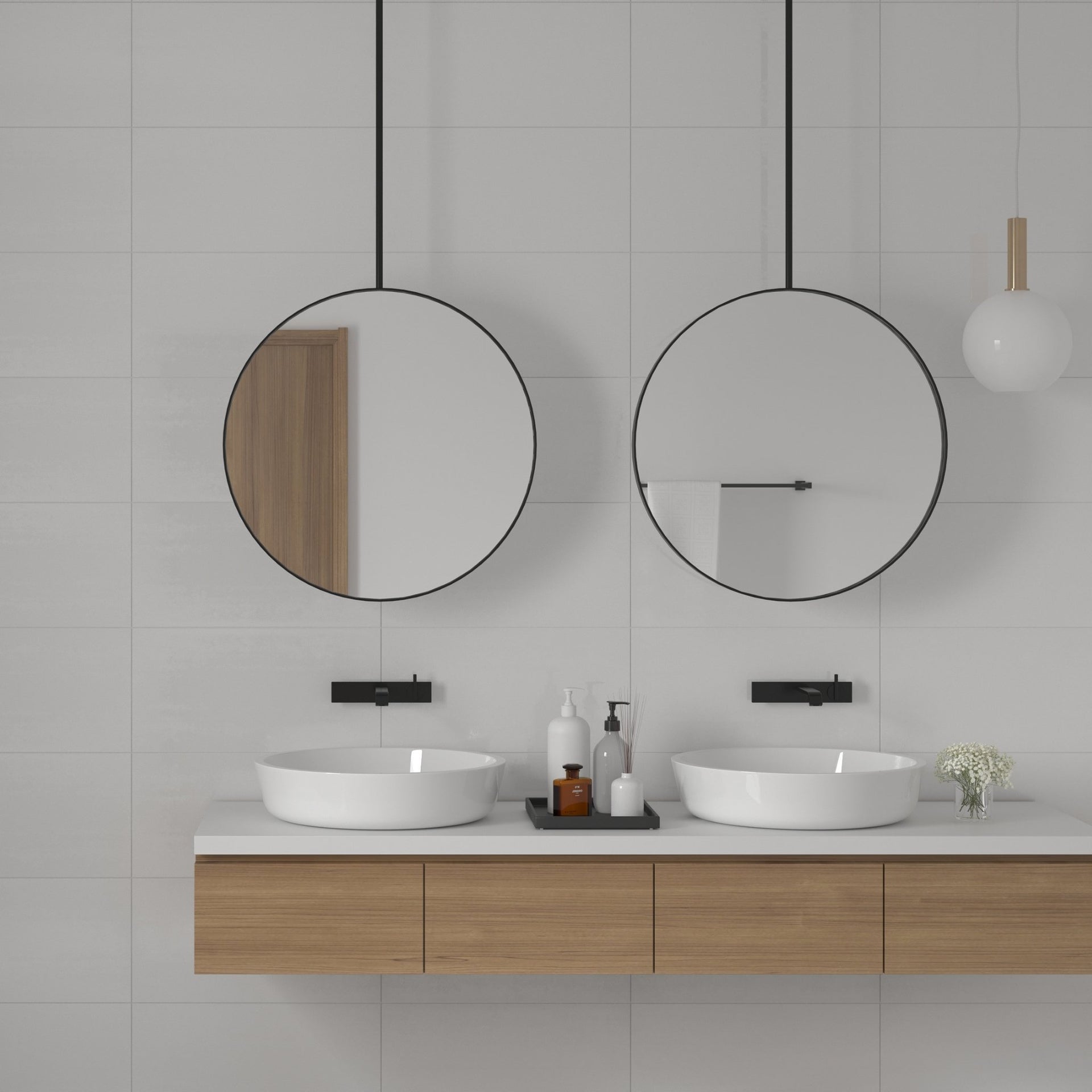 Modern bathroom with two round mirrors, white sinks, and wooden cabinets on a light grey metallic wall tiles.