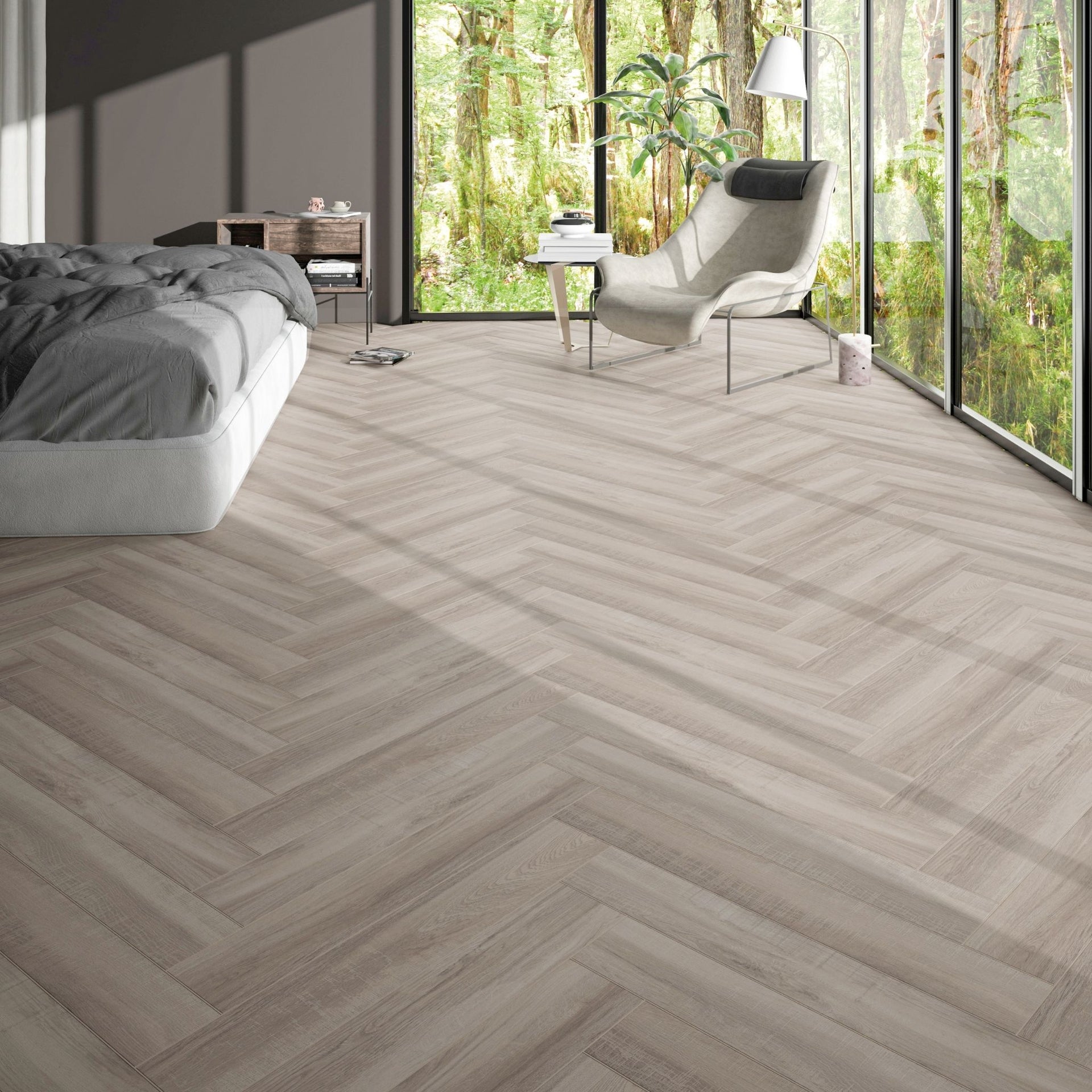 Modern bedroom with ordu greige grey beige wood-effect floor tiles in herringbone pattern, bed, and chair near large windows with a view of greenery.