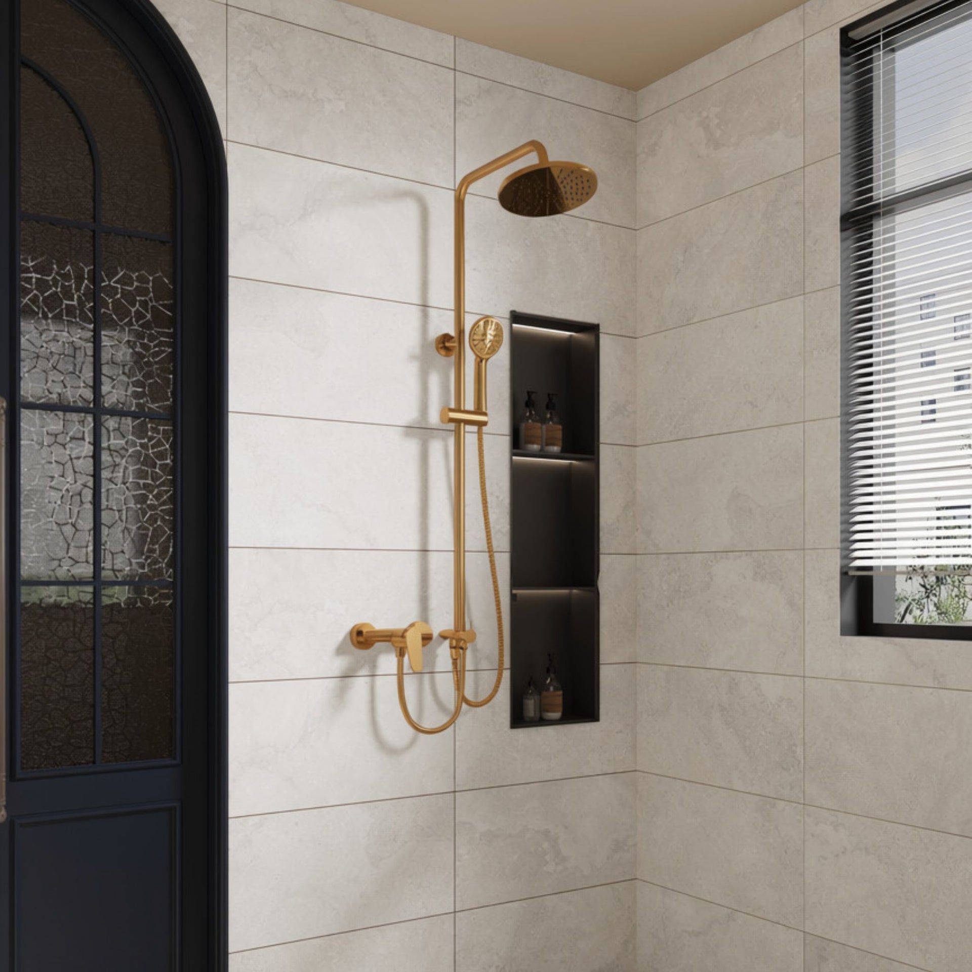 A modern  bathroom corner with off white Oxton stone effect tiles, featuring a gold-finished shower system with a round rain head, handheld shower, and wall-mounted shelf with small bottles.