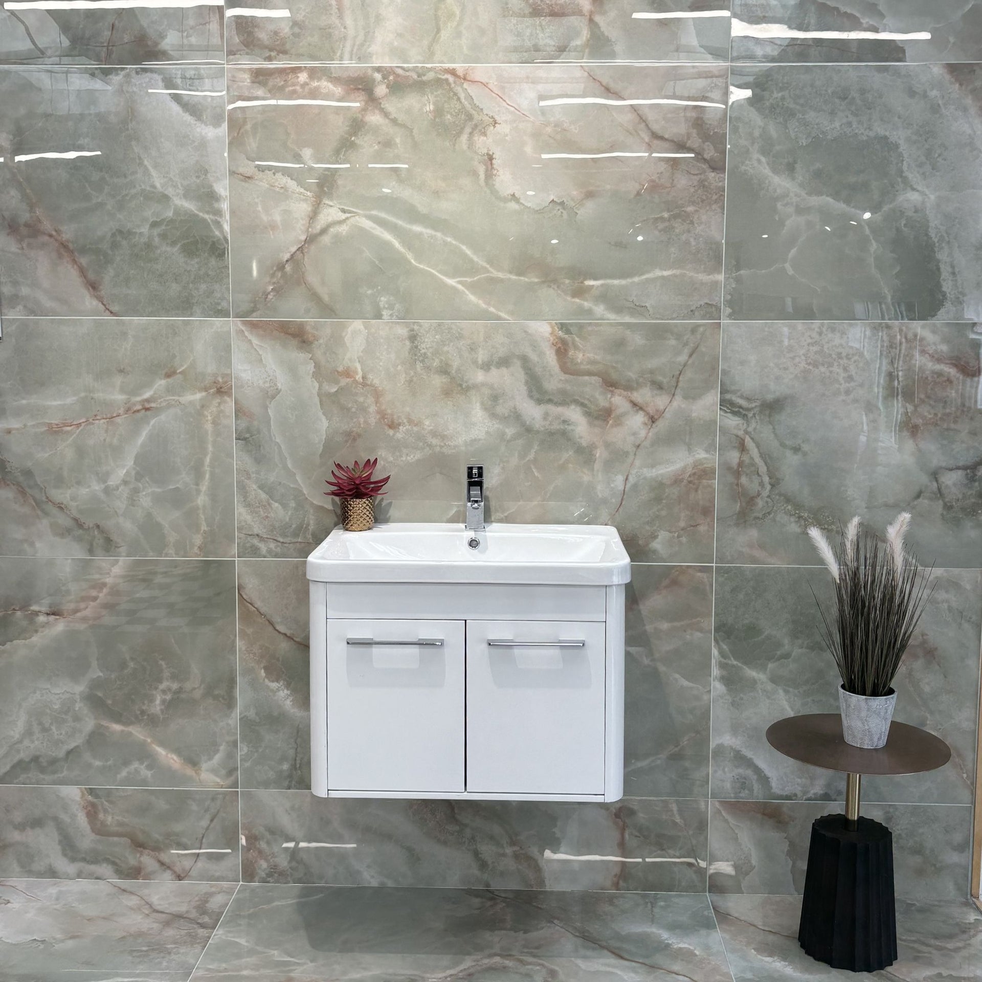 Bathroom vanity with sink against a green marble-patterned wall