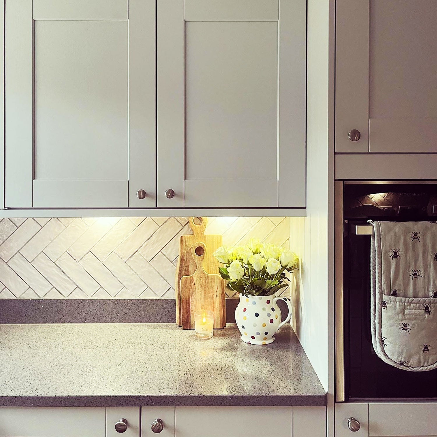 white kitchen with shimmer white gloss tiles with ark grout as backsplash. 