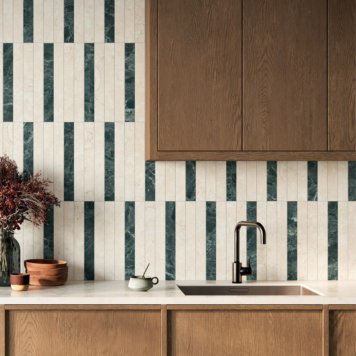 A modern kitchen backsplash featuring vertical stripes of Sillara dark green marble look and white stone effect tiles, paired with warm wood cabinetry, a white marble countertop, and a matte black faucet.