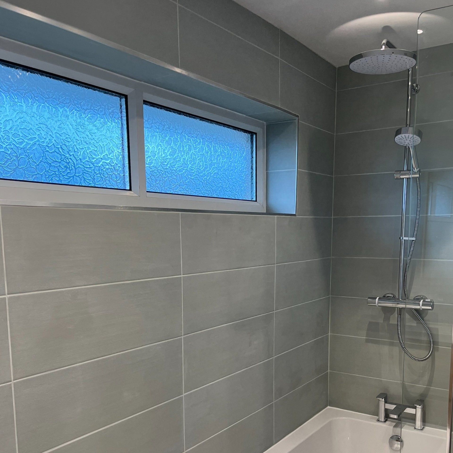 bathroom shower and bathtub with sage green tiles