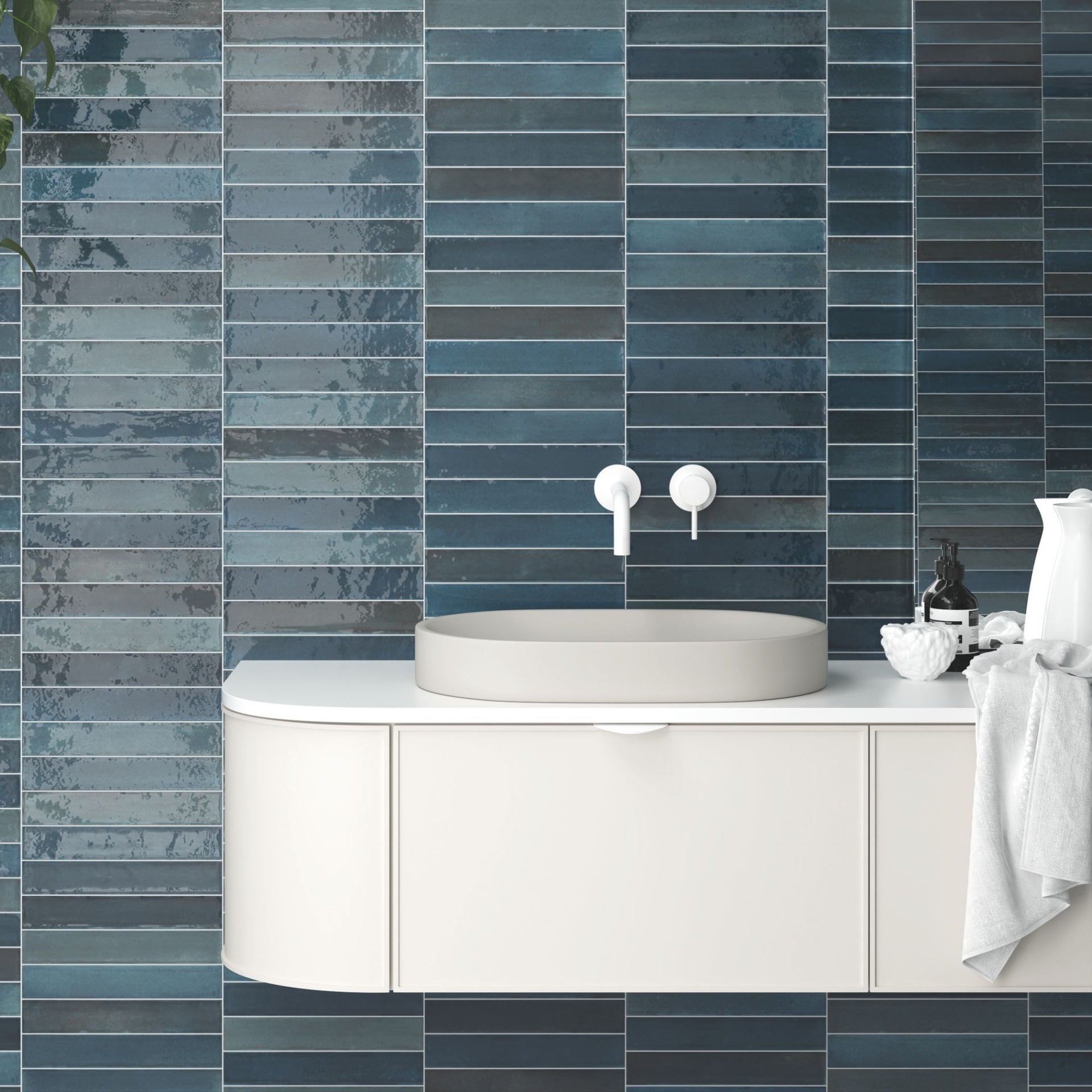 Bathroom with blue Tortosa gloss tiled wall, white sink, and cabinet.