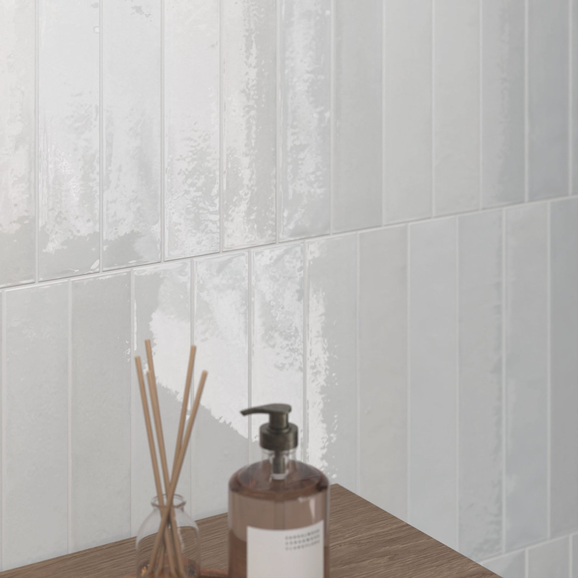 Bathroom close up of Tortosa glossy white wall tiles in the background and wooden furniture