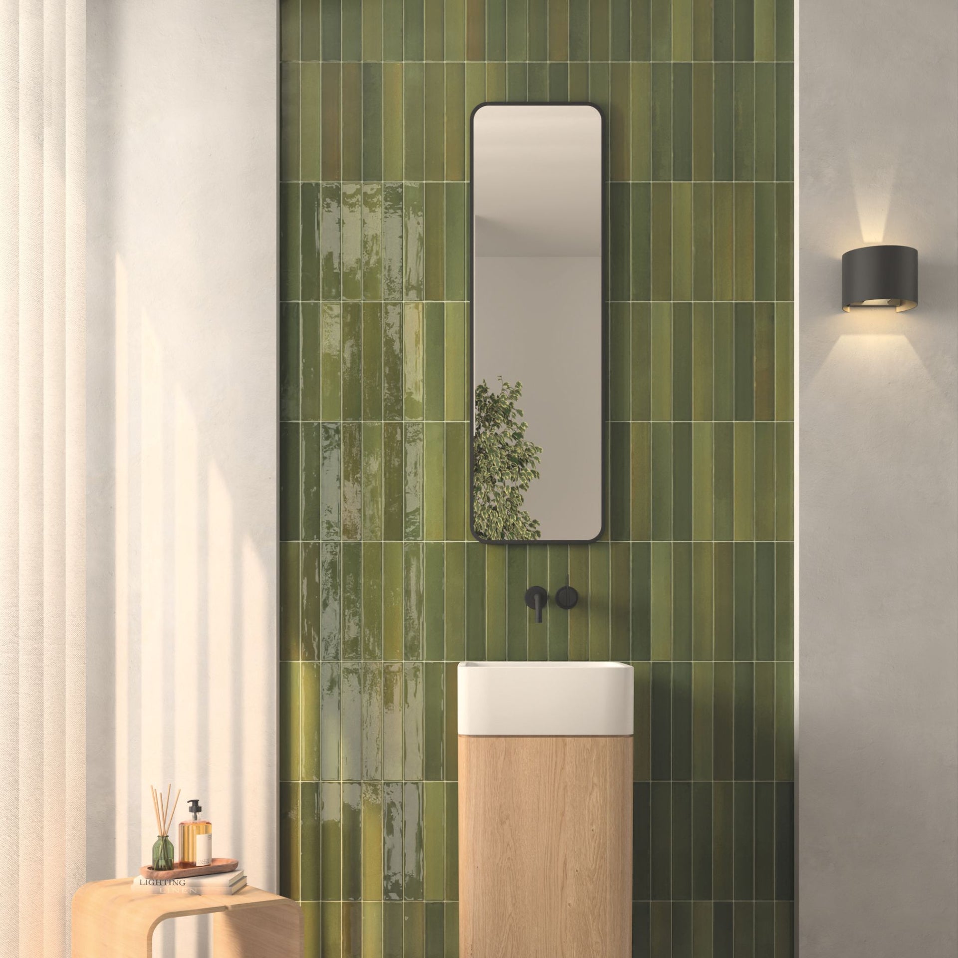 Bathroom with green tortosa zellige artisan gloss tiled wall, mirror, and wooden vanity.

layout-bathroom