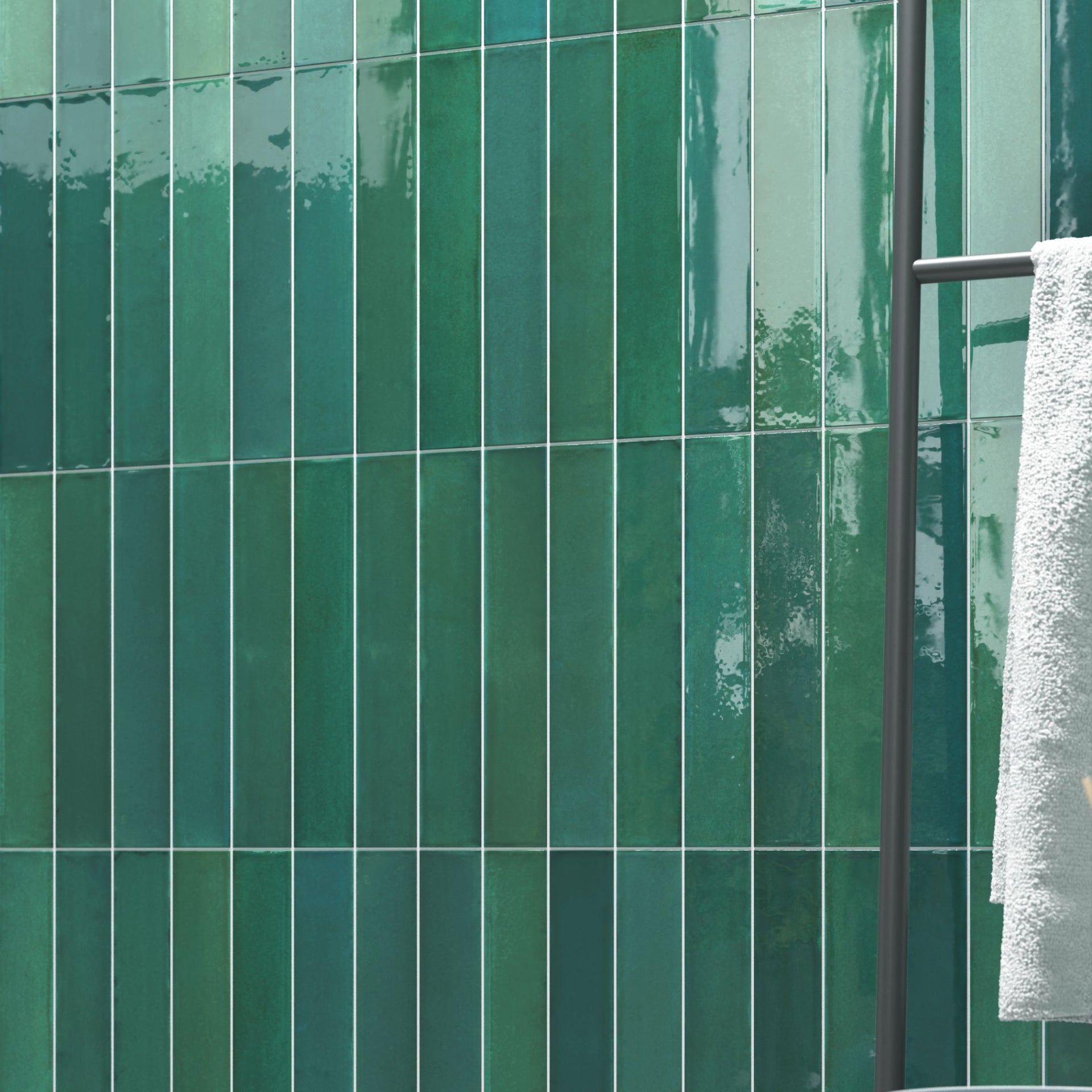 Tortosa glossy green tonal artisan tiled wall with a towel hanging on a rack