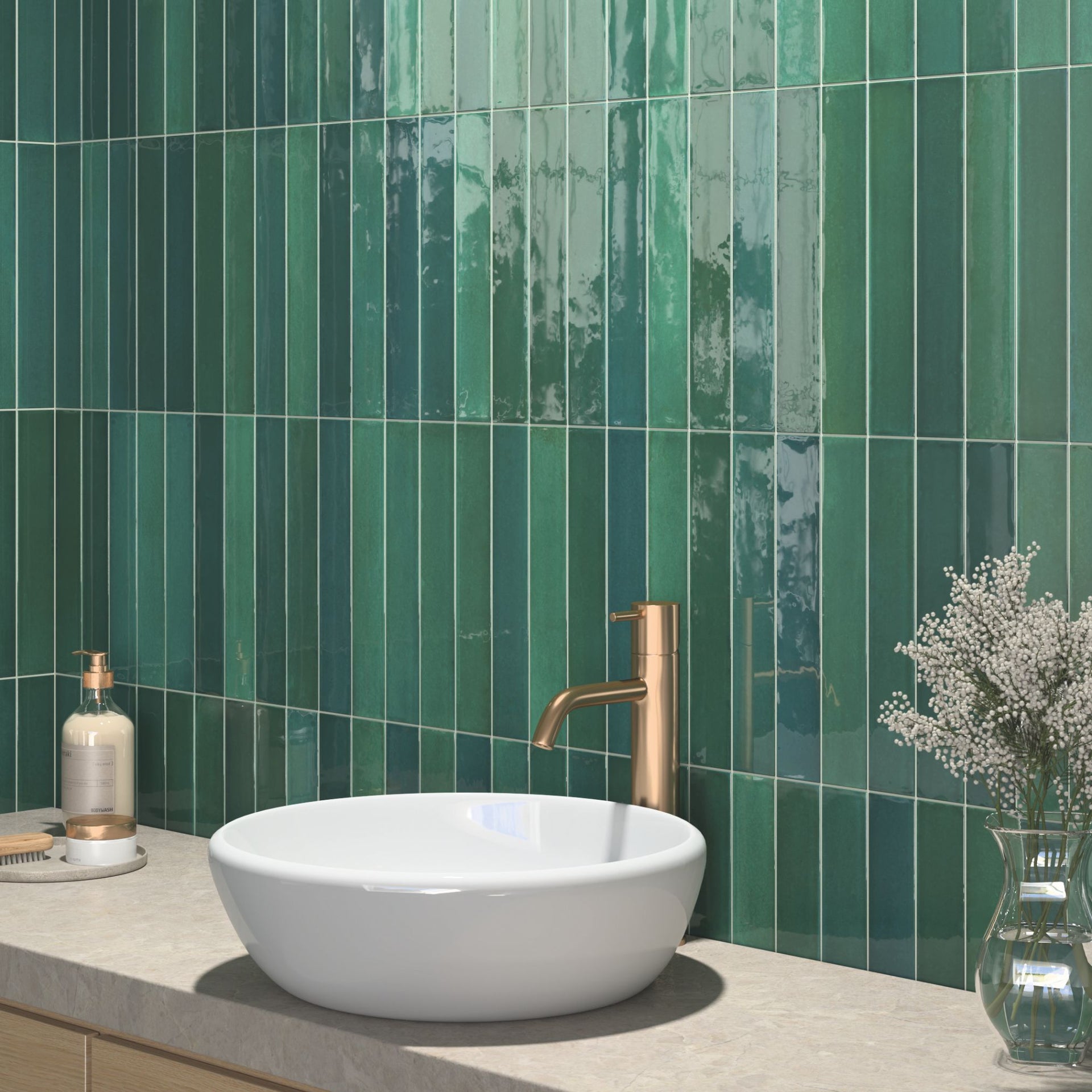 Bathroom with green glossy tonal tiled wall, white sink, and copper faucet.