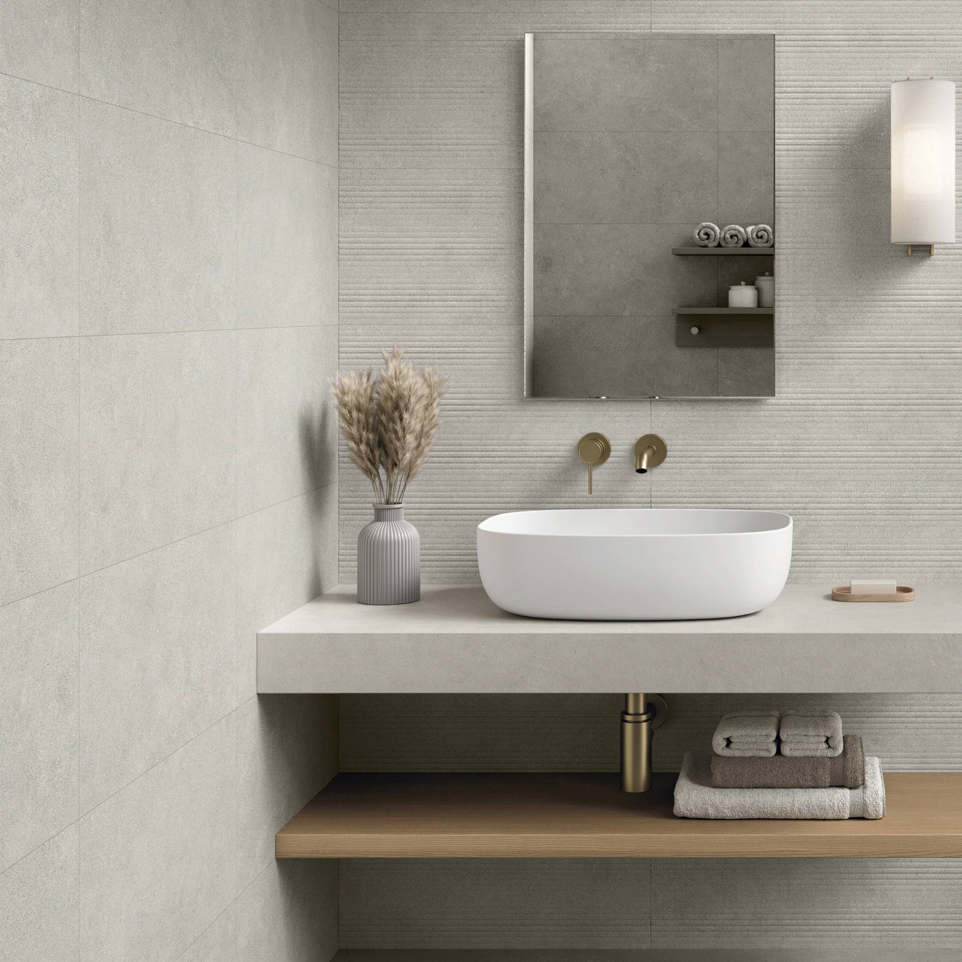 Modern bathroom with grey matt stone effec ttiles, vanity with a sink, mirror, and decorative elements.